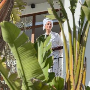 a woman in a towel standing next to a plant at Boutique Apartments Marsol Ibiza in Santa Eularia des Riu