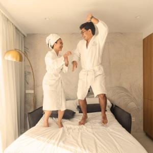 a man and a woman standing on top of a bed at Boutique Apartments Marsol Ibiza in Santa Eularia des Riu