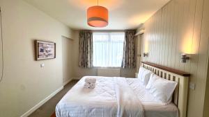 a bedroom with a bed with a stuffed animal on it at The Lodge, Whitethorns, Myrtleville in Myrtleville