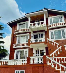 a red brick building with white balconies on it at SkyRidges in Srinagar