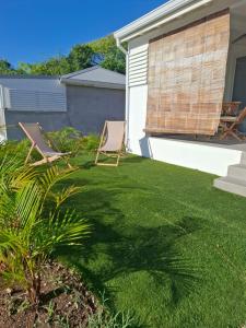 a yard with two lawn chairs and a house at Zion in Capesterre