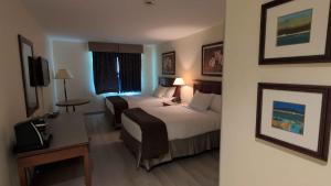 a hotel room with two beds and a table at Hôtel St-Bernard in St-Bernard de Lacolle