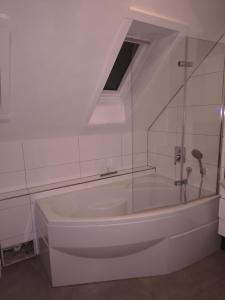 a white bath tub with a window in a bathroom at Appartement 34 in Schwäbisch Hall