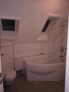 a white bathroom with a tub and a toilet at Appartement 34 in Schwäbisch Hall