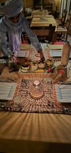 a woman sitting at a table with food on it at Roaming Desert Luxury Camp in Lac Yasmins