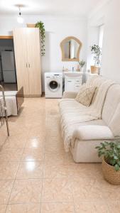 a living room with a couch and a washing machine at Гостевой дом Москва in Aktobe