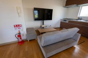 a living room with a couch and a flat screen tv at Seaside Deer Shiraoi in Shiraoi