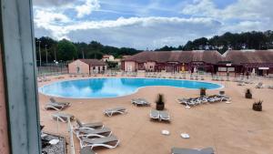 a swimming pool with lounge chairs and a resort at Résidence Mes Amours d'Enfants - Les Villas du Lac in Soustons