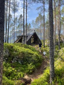 a person walking in front of a cabin in the woods at Lindum Hotell in Suldalsosen