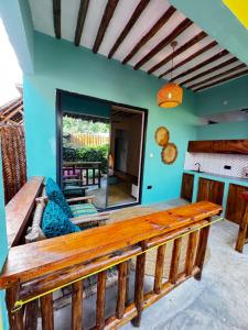 a porch with a wooden bench and a mirror at FURAHA GARDEN Rooms in Kendwa