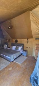 a bedroom with a large bed in a tent at Roaming Desert Luxury Camp in Lac Yasmins