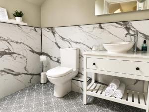 a bathroom with a white toilet and a sink at Ardvreck House in Ullapool +33 photos