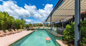 a swimming pool with chairs and a building at ibis Valence Sud in Valence
