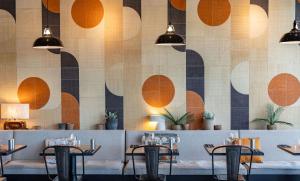 a dining room with tables and chairs and a wall at ibis Valence Sud in Valence