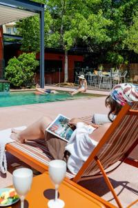 a woman laying on a lounge chair reading a magazine at ibis Valence Sud in Valence