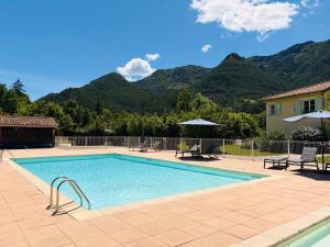 a swimming pool with mountains in the background at Le Vercors Park in Die