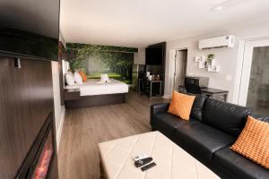 a living room with a couch and a bed at Envi Boutique Hotel Henderson-Evansville South in Henderson