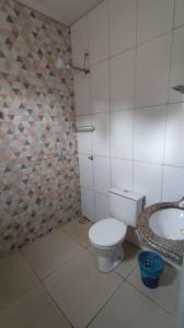 a bathroom with a toilet and a sink at Hotel Gramados in Porangatu