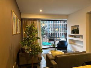 a living room with a couch and a plant in it at Distrito prime 1-303 in Bogotá