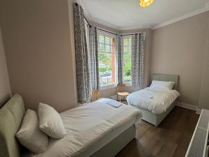 a small bedroom with two beds and a window at Charlie Hotel in London