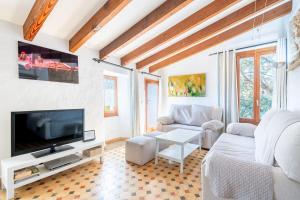 a living room with a couch and a tv at Casa Es Putxet in Cala Ratjada