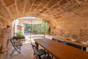 a patio with a table and chairs and an umbrella at Casa Es Putxet in Cala Ratjada