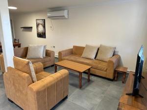 a living room with two couches and a table at carmel cabins suite 7 in Yājur