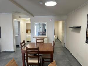 a dining room with a wooden table and chairs at carmel cabins suite 7 in Yājur