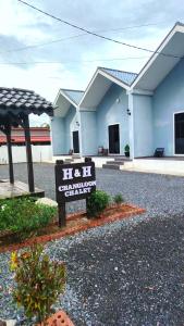 a house with a sign in front of it at H&H Changloon Chalet in Changlun