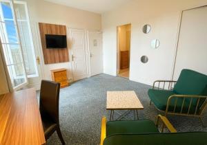 a living room with a couch and chairs and a table at Logis Hôtel Du Château - Combourg, Proche Saint-Malo in Combourg