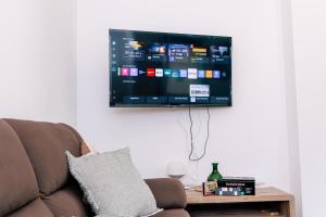 a flat screen tv hanging on a wall above a couch at Villa SOL Lago di Endine in Ranzanico