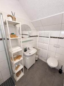 a white bathroom with a sink and a toilet at Ferienwohnung am Bodden in Barth +10 photos