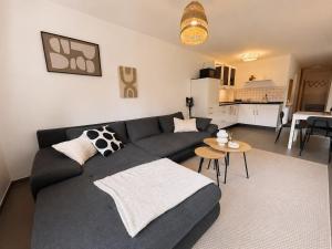 a living room with a gray couch and a table at Ferienwohnung am Bodden in Barth