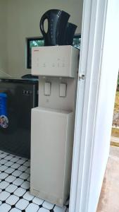 a refrigerator with a stack of dishes on top of it at H&H Changloon Chalet in Changlun