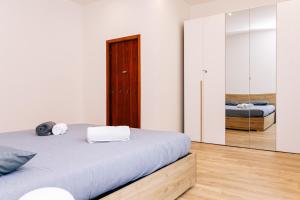 a white bedroom with a bed and a mirror at Villa SOL Lago di Endine in Ranzanico