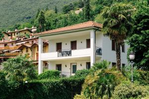 a building with a palm tree in front of it at Villa SOL Lago di Endine in Ranzanico