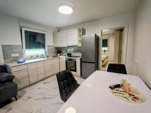 a kitchen with a table and chairs and a refrigerator at Apartma Alpine Gateway in Komenda