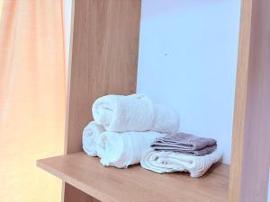 a pile of towels on a shelf in a bathroom at Guest House Kasa Garden in Durrës +49 photos