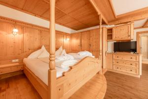 a bedroom with a bed in a room with wooden walls at Alpenpension Hotel Pfurtscheller in Neustift im Stubaital