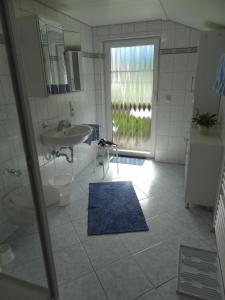 a bathroom with a sink and a toilet and a mirror at Gästehaus Koros in Fischen +32 photos