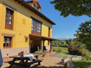 a yellow house with a picnic table in front of it at El Balcón Del Profesor in Cereceda
