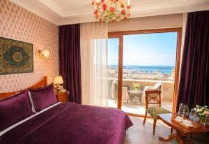 a bedroom with a purple bed and a view of the ocean at West inn Luxury Baku in Baku