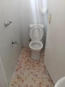 a bathroom with a toilet and a tiled floor at Luxe-homestay 1 Bed Executive Studio in Eldoret