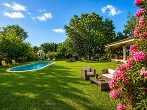 a yard with a swimming pool and flowers at Holibai As Landras Piscina y vistas al Miño, Tomiño in Tomiño