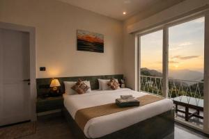 a bedroom with a large bed and a large window at Anuttara Retreat in Narendranagar +19 photos