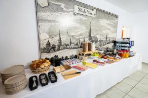 a bakery counter with food on it with a picture on the wall at Hotel Villa Sulmana in Neckarsulm