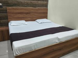 a bedroom with a bed with a wooden headboard at Hotel Kanhaiya Inn in Haridwār +9 photos