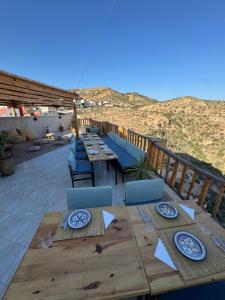 a wooden table with chairs and plates on a deck at Manapany Surf Camp in Tamraght Ouzdar +22 photos