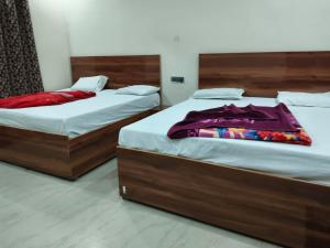 two beds sitting next to each other in a room at Hotel Kanhaiya Inn in Haridwār