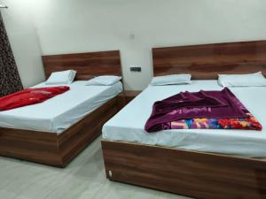 two beds sitting next to each other in a bedroom at Hotel Kanhaiya Inn in Haridwār